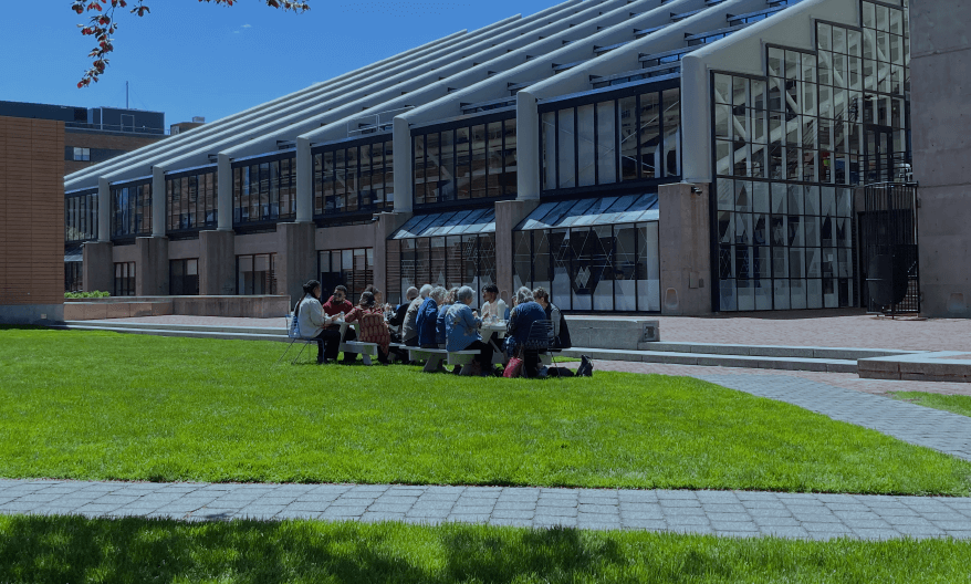 Loeb fellows sitting in backyard of Gund Hall.